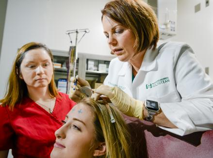 Kimberly Patterson, course director and EEG and EMG coordinator in MSU’s Department of Neurology and Ophthalmology, demonstrates aspects of what a neurodiagnostic technologist does to a prospective student