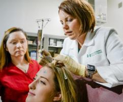 Kimberly Patterson, course director and EEG and EMG coordinator in MSU’s Department of Neurology and Ophthalmology, demonstrates aspects of what a neurodiagnostic technologist does to a prospective student